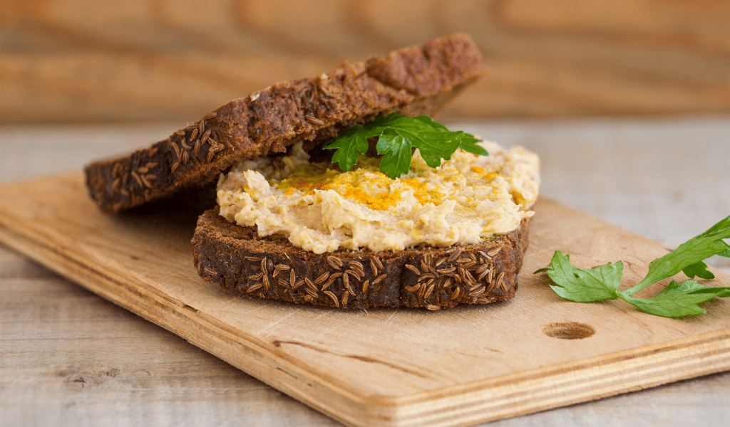 boterham hummus op plank neutrale achtergrond