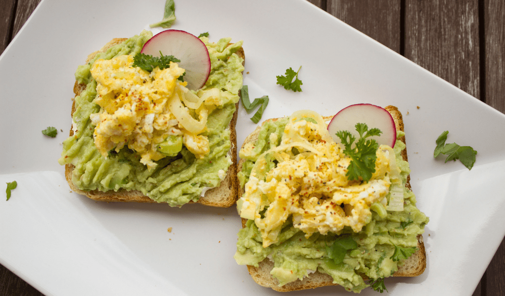 boterham avocado en tofu ei op wit bord